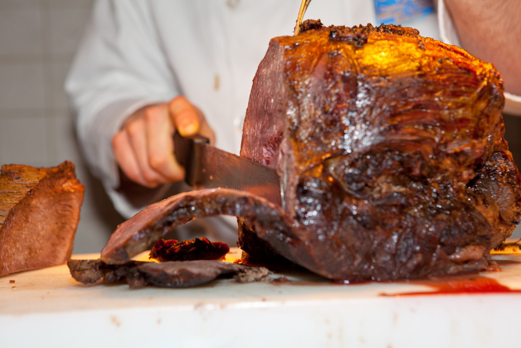 smoked beef being sliced by chef